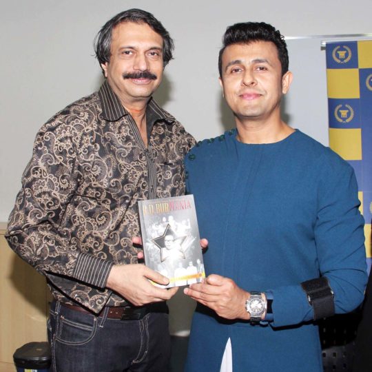 Author Chaitanya Padukone presents a copy of RD BurMania to celebrated singer-actor Sonu Nigam.